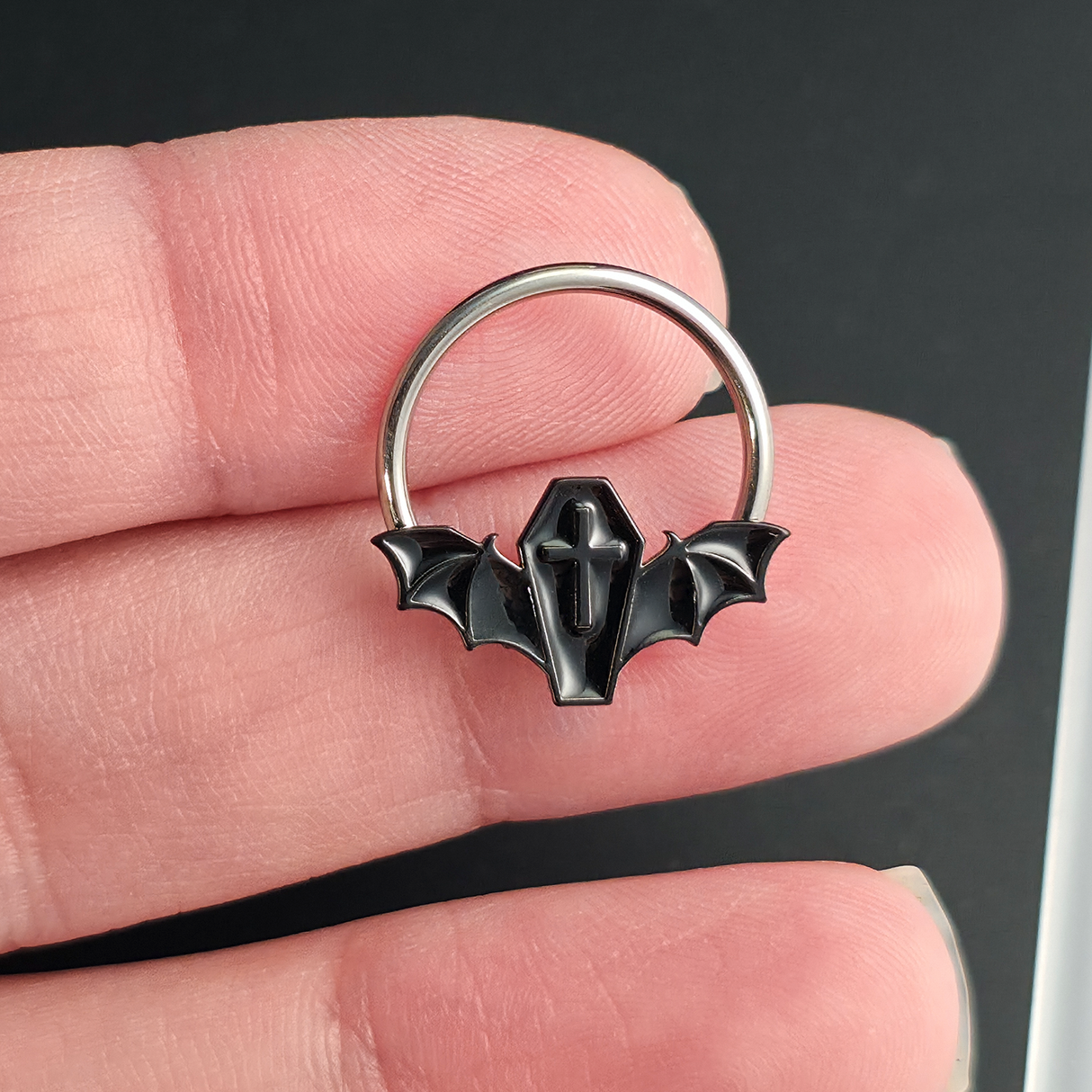 black coffin bat septum ring on hand