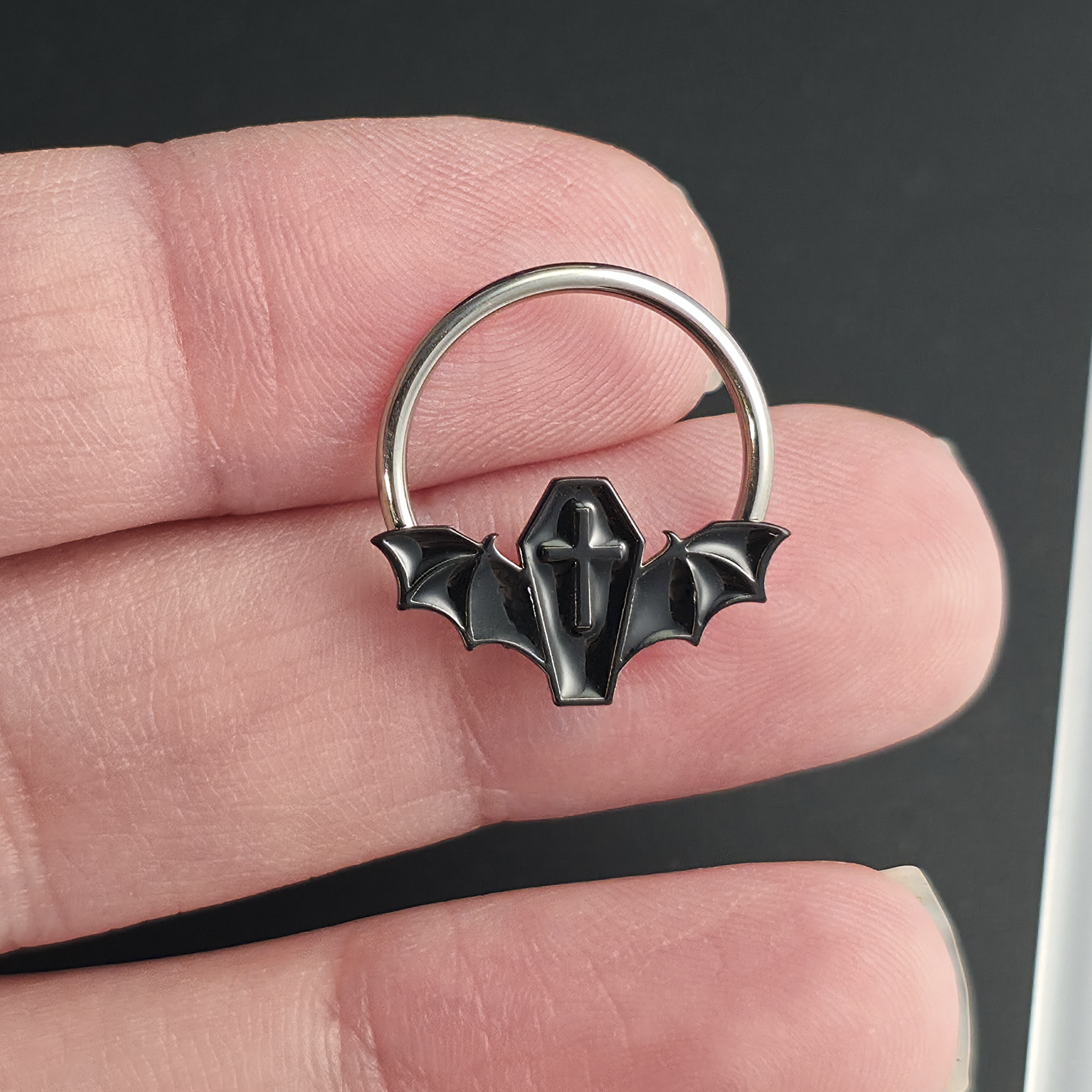 black coffin bat septum ring on hand