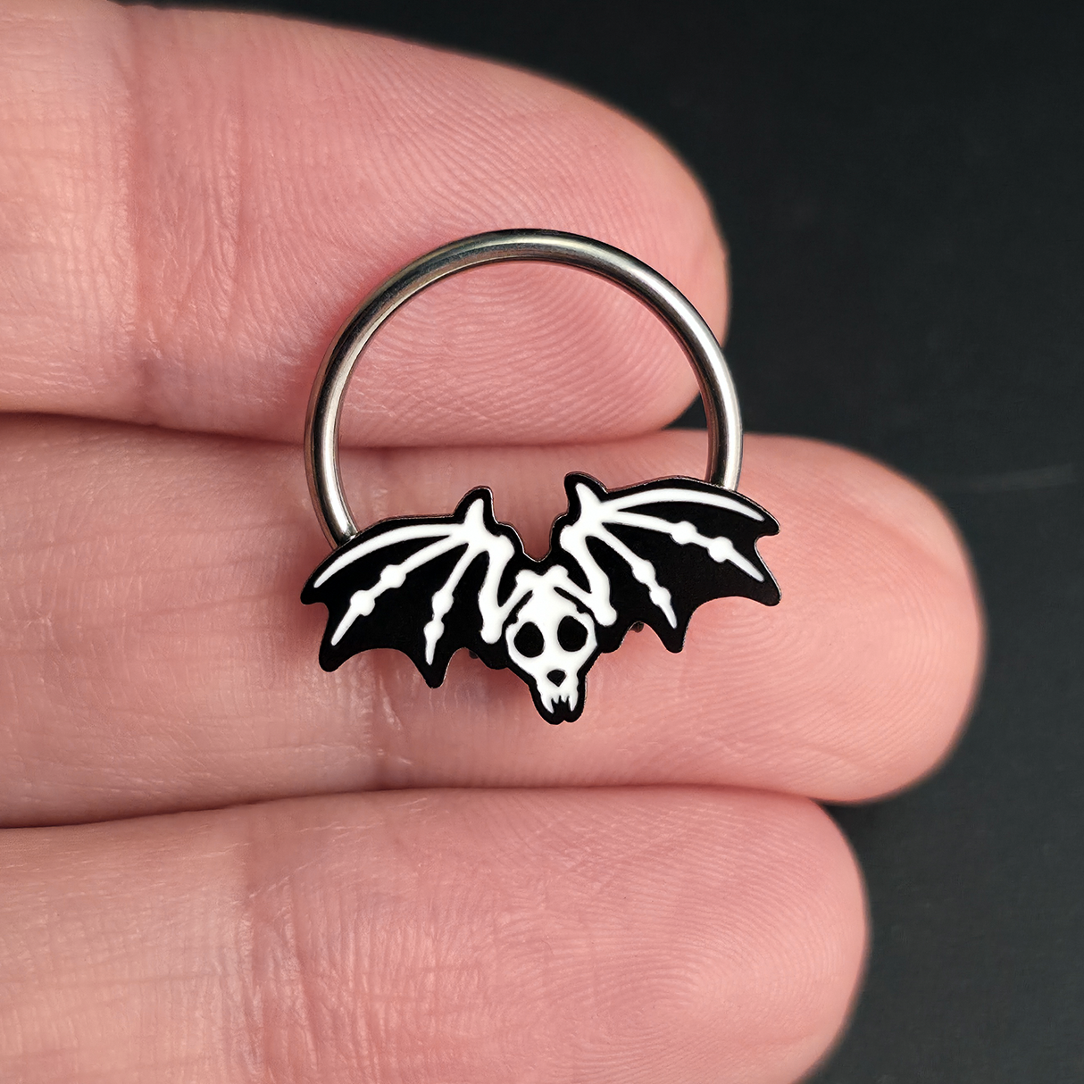 bat skeleton septum ring on hand