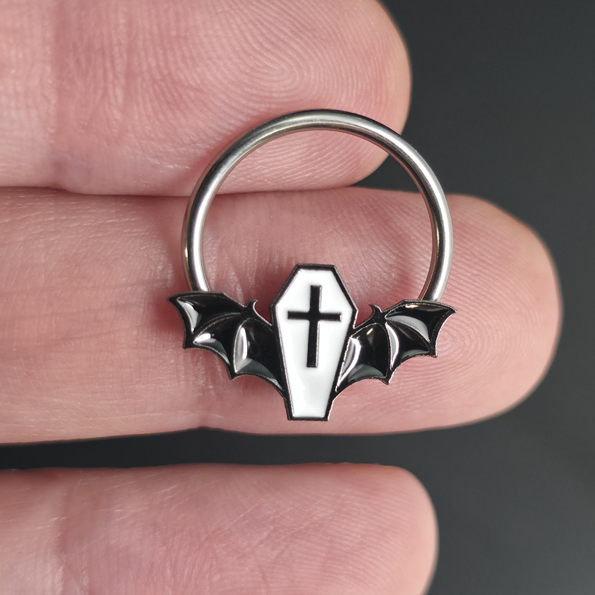 black and white coffin bat septum ring on hand