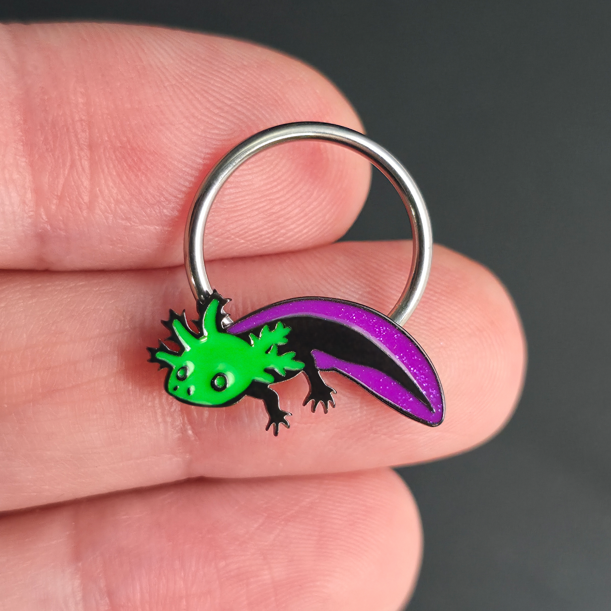 green and purple axolotl septum ring on hand