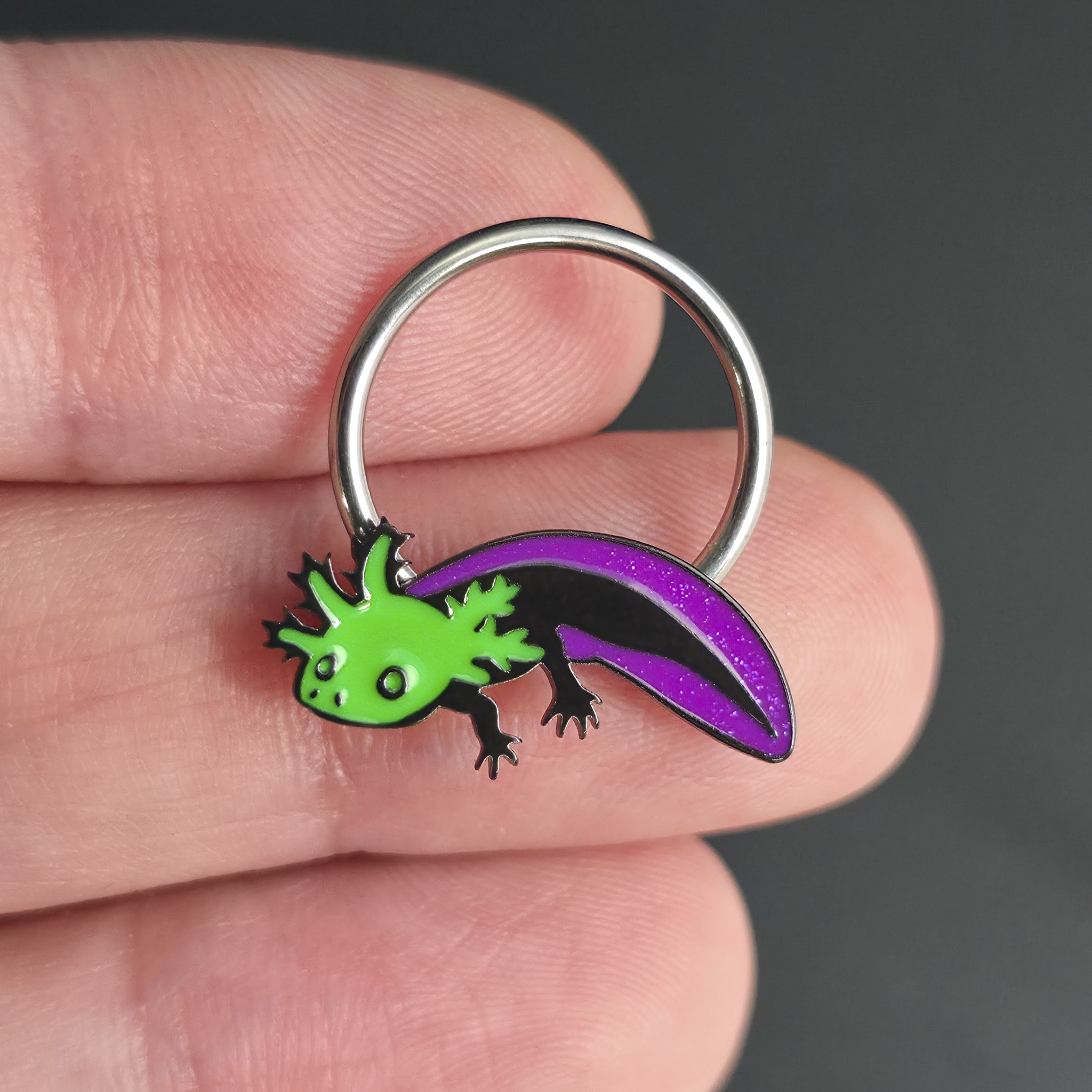 green and purple axolotl septum ring on hand