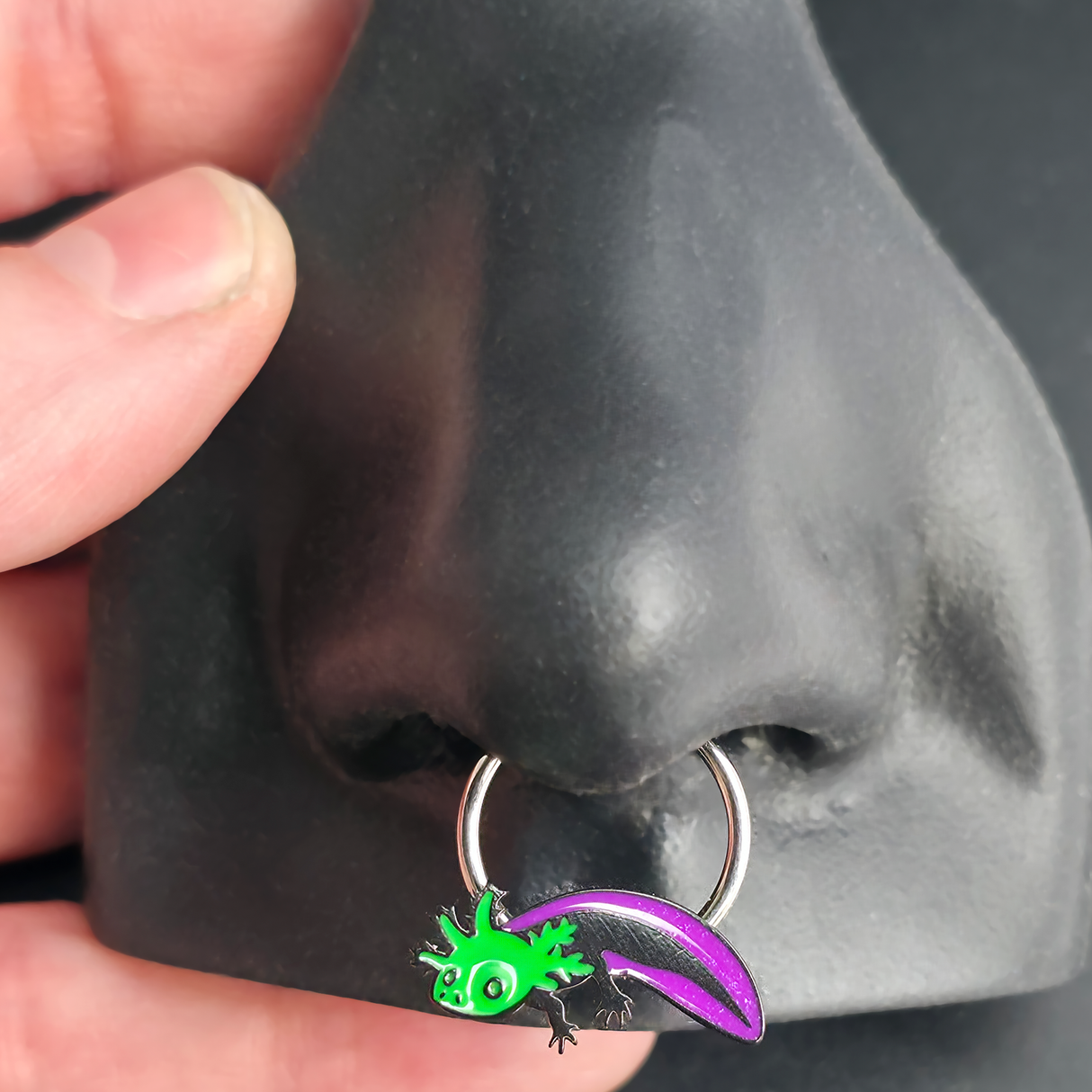 green and purple axolotl septum ring in nose
