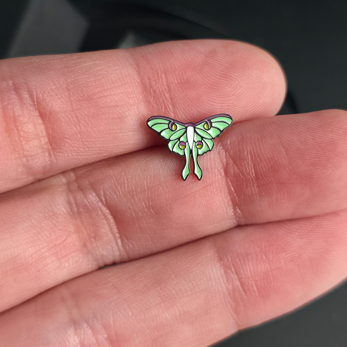 luna moth nose stud and earring on a hand for size reference