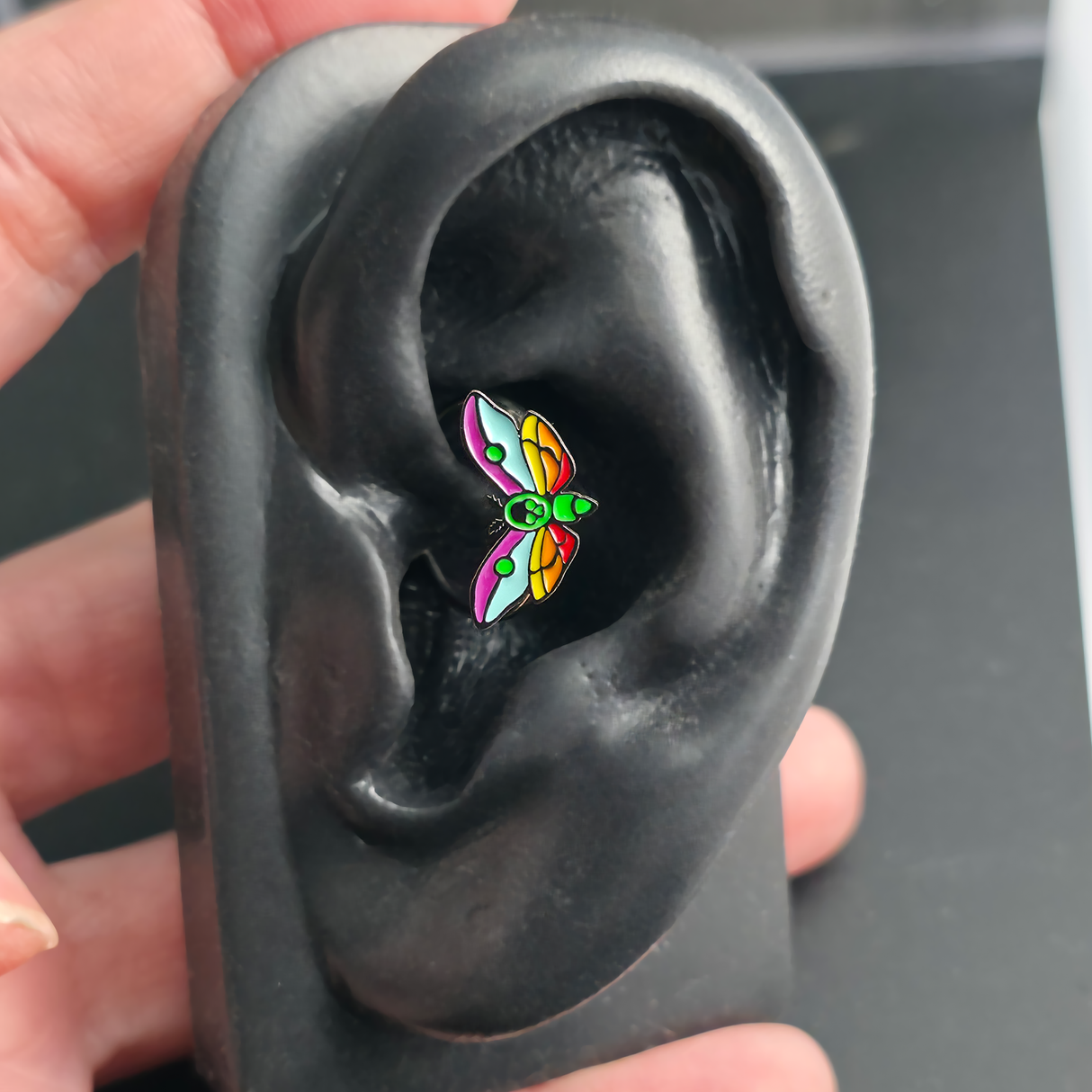 rainbow death moth daith earring in ear