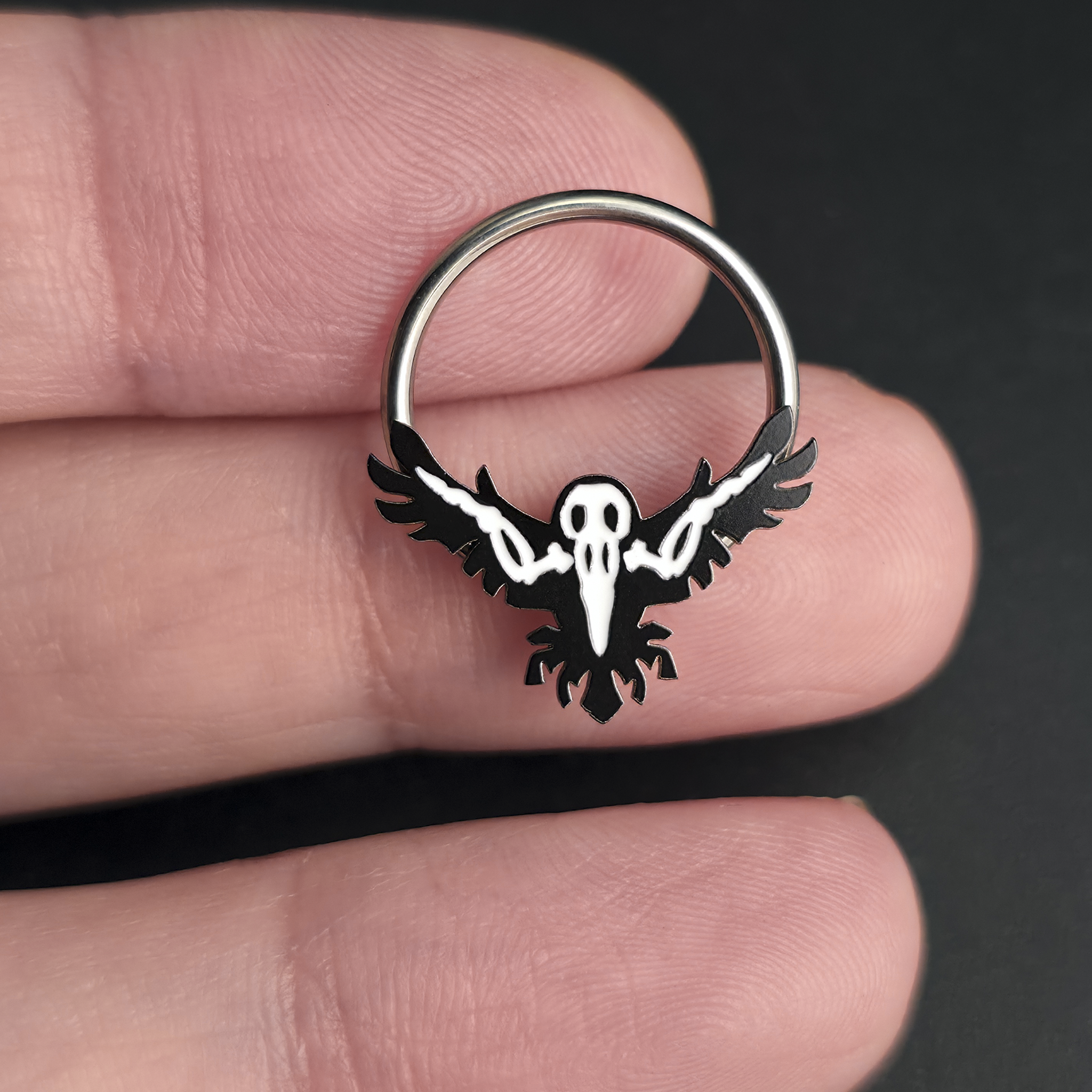 raven skeleton septum ring on hand