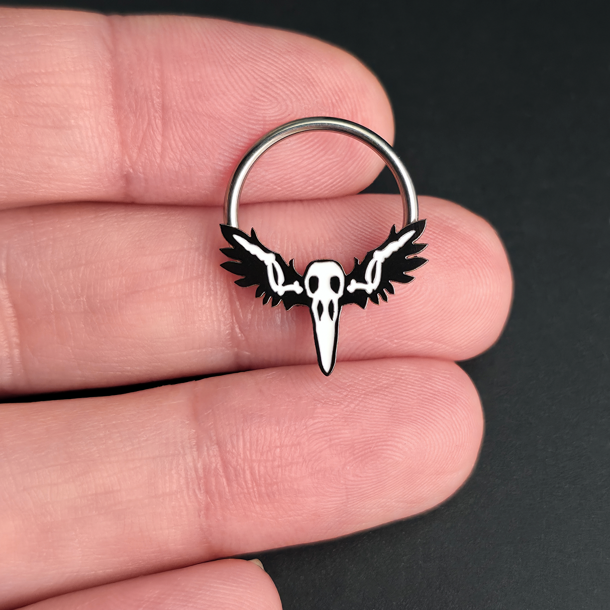 raven skull with wings on hand