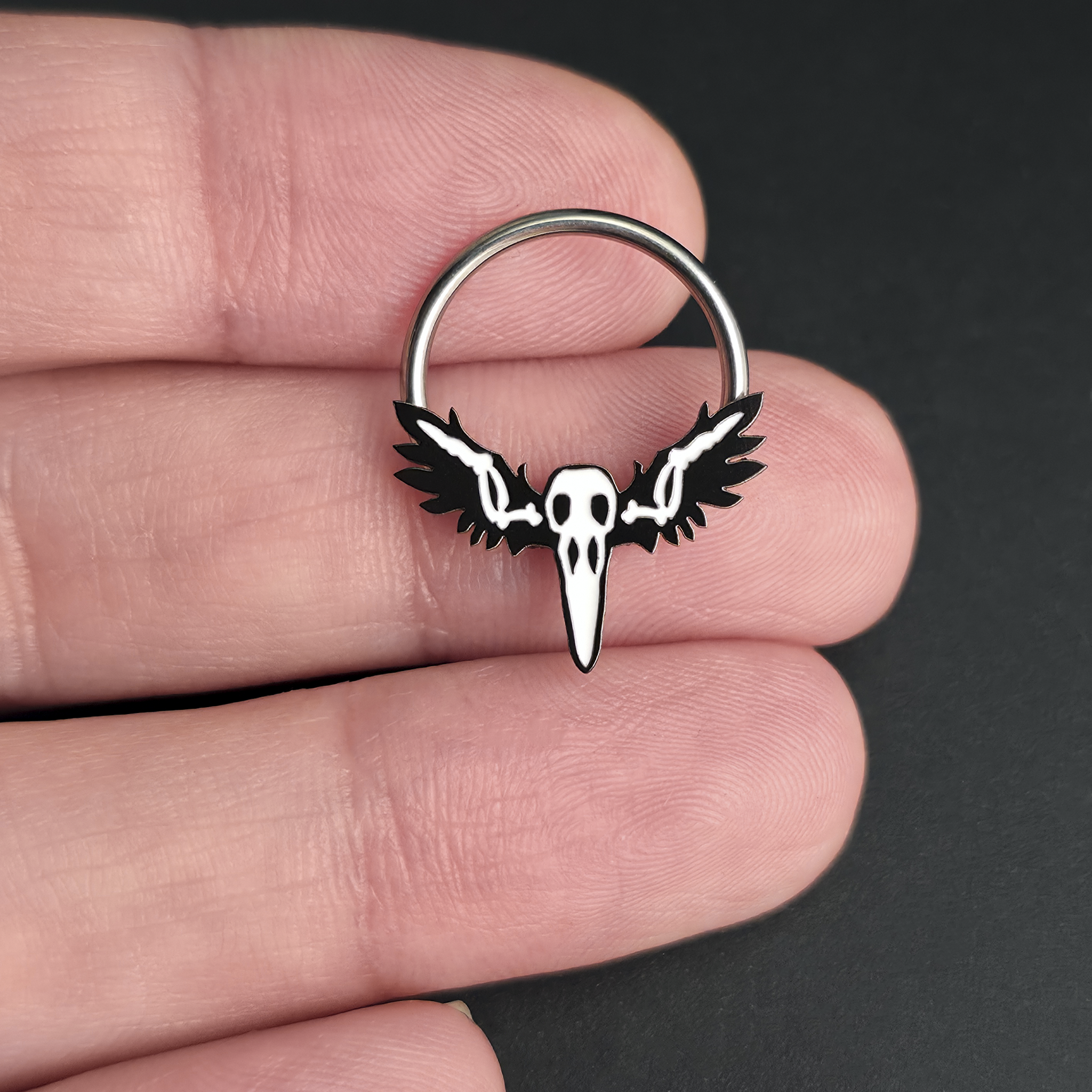 raven skull with wings on hand