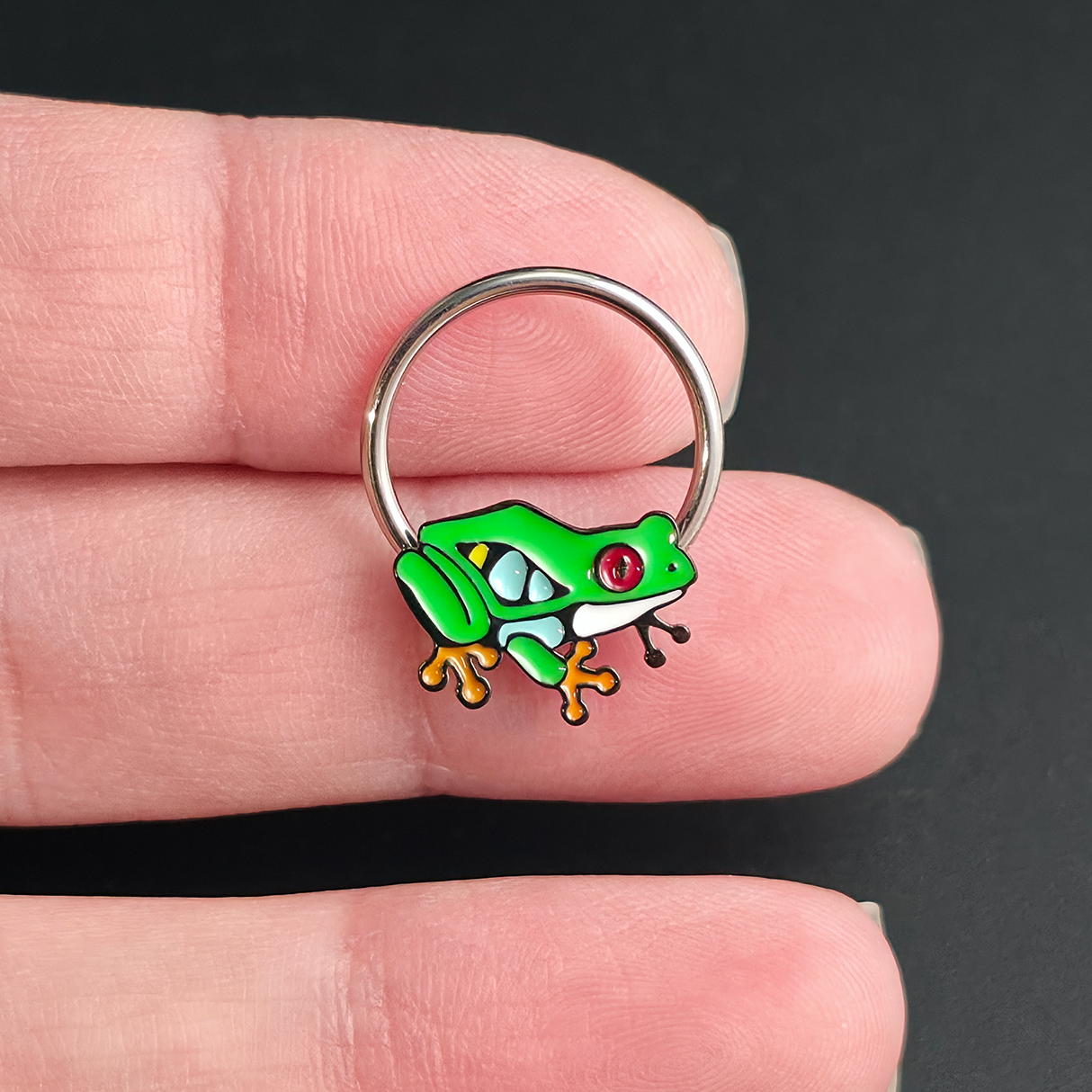 red eyed tree frog septum ring on hand