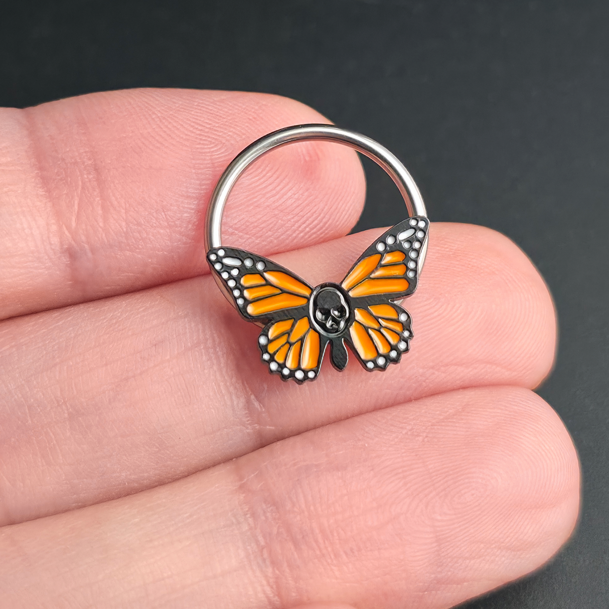 skull butterfly septum ring on hand