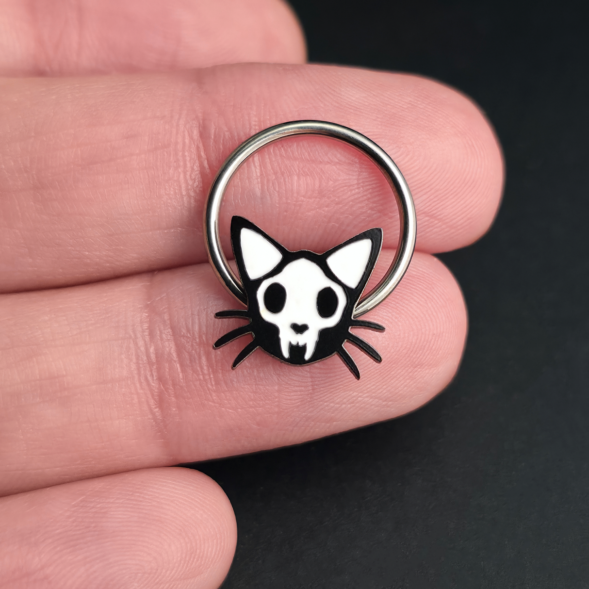 cat skull septum ring on hand