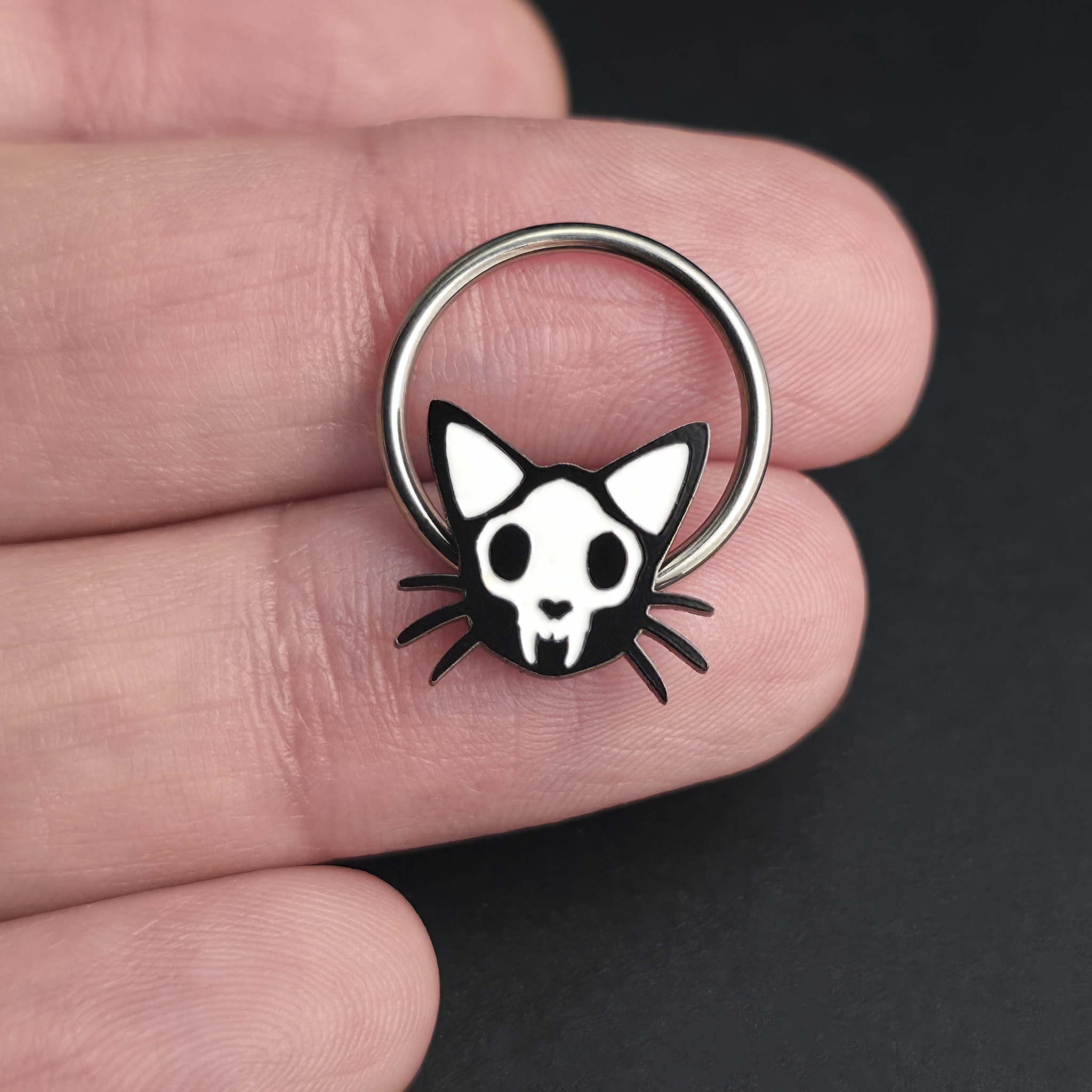 cat skull septum ring on hand