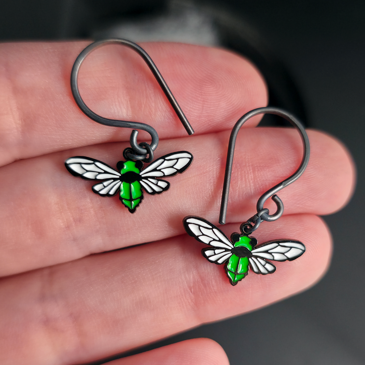 cicada dangle earrings on hand