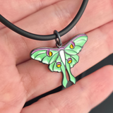luna moth necklace on hand