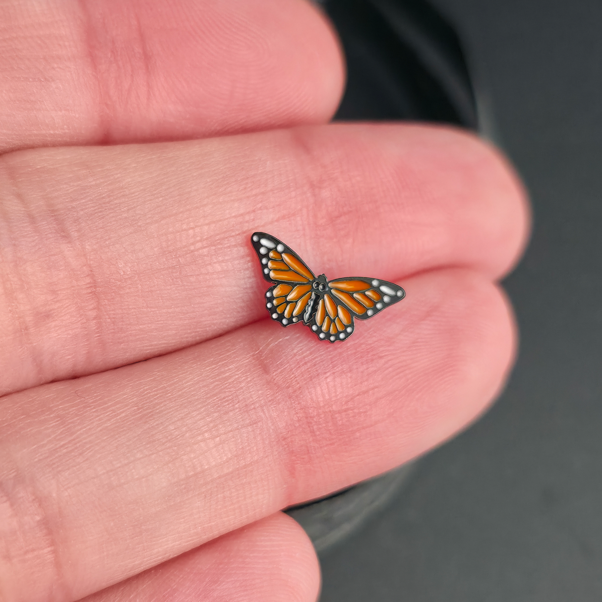 monarch butterfly nose stud and earring on a hand for size reference
