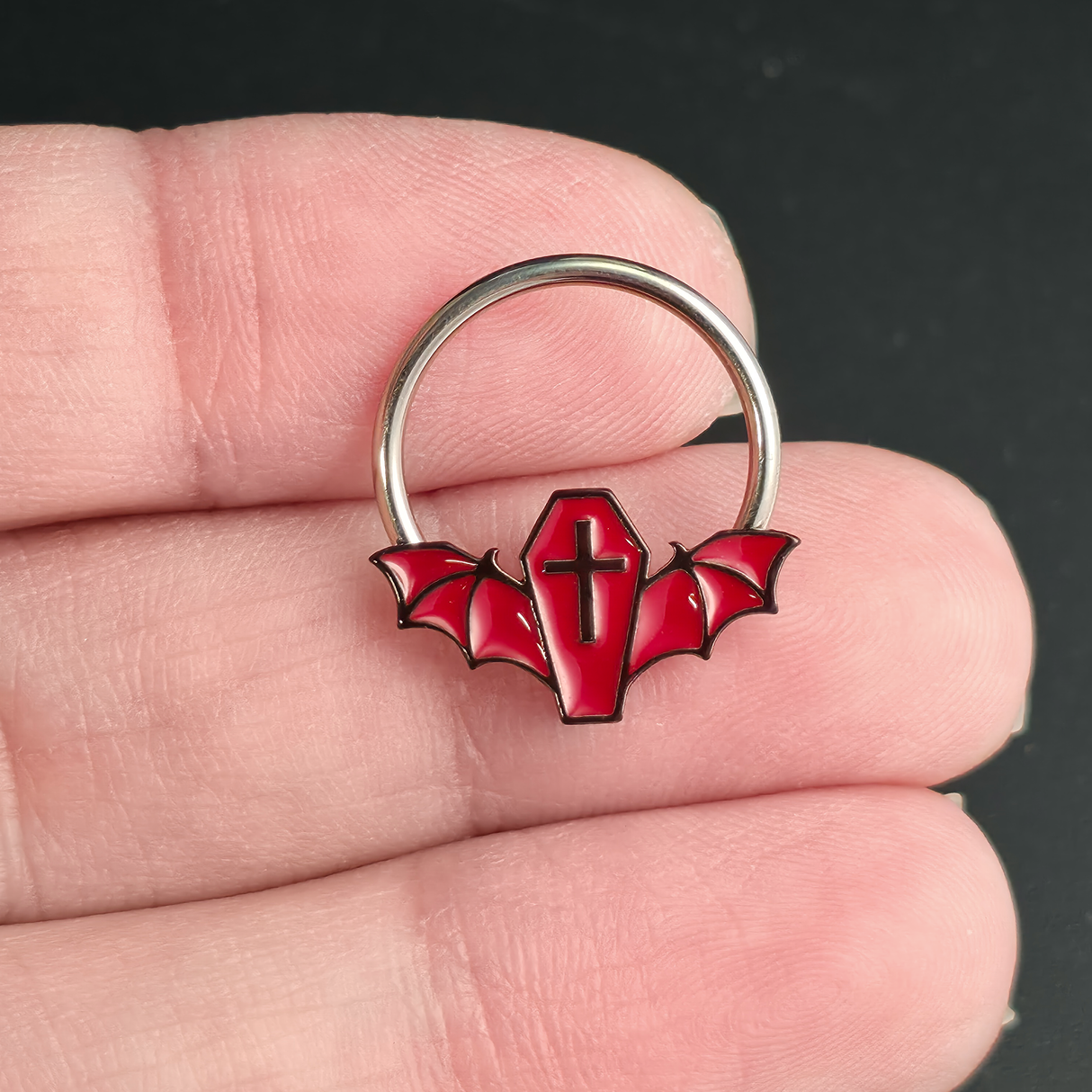 red coffin bat septum ring on hand